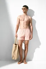 Short de baño color rosa con textura de sirsaca, elástico y cordón ajustable en la cintura, bolsillos laterales, bolsillo trasero ribeteado, aberturas laterales cortas y suspensor interior de malla.