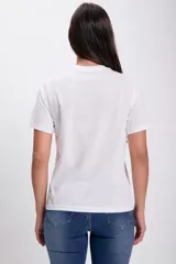 Remera blanca de algodón con estampado de una flor amarilla y hojas verdes, con la frase "The world in bloom".
