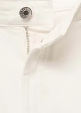 Short blanco de tiro medio con cierre de cremallera y botón, bolsillos laterales y pinzas delanteras. Confeccionado en tejido de algodón estilo tejano vaquero.