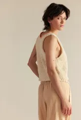 Top tejido de punto color crudo, con escote en V y borde tejido en color salmón.