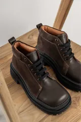 Borcegos negros de cuero charol, con punta cuadrada, cordones y suela track.