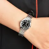 Reloj análogo Casio para mujer, modelo LTP1308D-1BVDF, con caja y pulsera de acero inoxidable plateado. Presenta una esfera negra con números arábigos blancos y manecillas plateadas. Incluye visualizador de fecha a las 3.