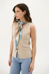 Chaleco color beige de tejido de punto con escote en V, cierre frontal con botones y bolsillos delanteros.