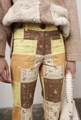 Pantalón de gabardina elastizada con estampado de pañuelos en tonos marrones, amarillos y beige.