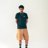 Bermuda color beige confeccionada en nylon liviano, con cintura elastizada con cordón, bolsillos laterales y bolsillos cargo de perfil limpio.