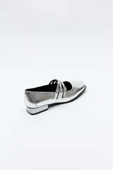Zapato tipo Mary Jane color negro con textura de reptil, de charol sintético con punta cuadrada y triple tira con hebillas.