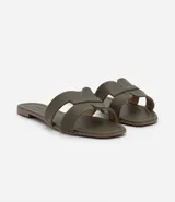 Sandalia plana de cuero sintético color negro, con puntera cuadrada y tiras anchas en forma de H.