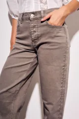 Jean de mujer color marrón topo, tiro medio, con corte barrel y puño doblado. Presenta costuras decorativas en la zona de las rodillas.