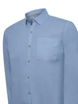 Camisa de manga larga color verde claro, confeccionada en popelina de algodón orgánico. Cuenta con cuello camisero, botones de madera, bolsillo en el pecho con logo bordado y protección UPF +20.