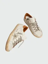 Championes Golden Goose modelo Super Star, color blanco con detalles en marrón y estrella en gris.