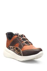 Zapatillas deportivas con estampado animal print de leopardo y cebra, detalles en charol rojo y base blanca.