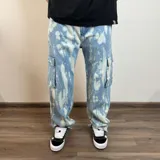 Pantalón jean cargo celeste con efecto tie-dye, corte holgado y bolsillos laterales.