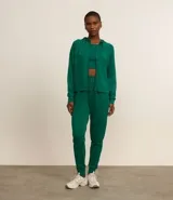 Campera deportiva verde esmeralda de modal, con capucha ajustable con cordón, cierre frontal con cremallera y bolsillos laterales.