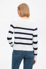 Sweater de punto negro con rayas horizontales blancas, cuello redondo y mangas largas.