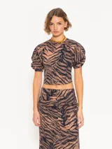 Top corto de mangas murciélago con estampado animal print en tonos marrón y negro. Tiene frunces en los laterales, puños elásticos, espalda abierta con broches y lazo.