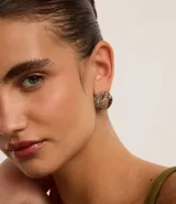 Set de tres pares de aros dorados: un par de aros gruesos con textura trenzada, un par de aros finos lisos y un par de aros tipo botón con textura ondulada.