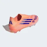 Championes de fútbol Adidas modelo F50 League, color naranja salmón con tres franjas laterales en azul oscuro. Presentan un diseño sin cordones con cuello adaptable y suela Sprintplate 360 de TPU con tacos moldeados.