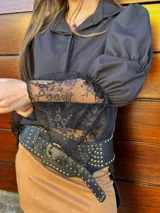 Camisa negra con mangas abullonadas, puños de encaje y cuello clásico.