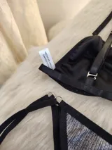 Conjunto de bikini plateado oscuro con detalles en negro, corpiño triangular y bombacha con tiras laterales.