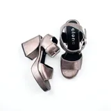 Sandalias de tacón con plataforma color plateado, con tira ancha sobre los dedos y tira con hebilla al tobillo.