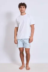 Short de baño celeste con estampado de gaviotas en negro y etiqueta con logo en la pierna.