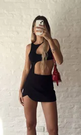 Body negro con escote asimétrico y aberturas en el abdomen.