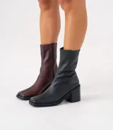 Bota corta color crema con textura de reptil, caña media, punta cuadrada, cierre lateral y taco de madera.