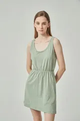 Vestido corto color beige, con escote en V, breteles finos y cintura elastizada.