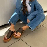 Sandalias de cuero vacuno color marrón con plataforma y tira ancha sobre el empeine.