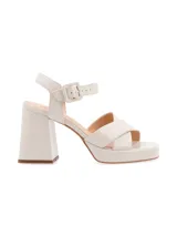 Sandalias de cuero color canela con plataforma y tacón ancho. Tiras cruzadas en el empeine y pulsera ajustable con hebilla en el tobillo.
