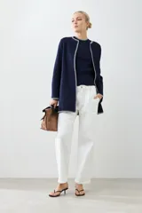 Saco tejido azul marino con pespuntes blancos en cuello, solapa, borde y puños.