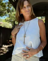 Gargantilla con hilo de algodón color camel y tres dijes de peces realizados en bronce, alpaca y plata 925.