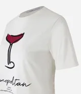 Remera de algodón color crema con cuello redondo y mangas cortas. Estampa frontal de una copa de Cosmopolitan y la inscripción "Cosmopolitan".