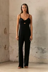 Mono largo negro de breteles finos, con escote cruzado y abertura en el abdomen. Pantalón de corte palazzo.