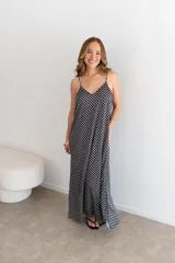 Vestido largo negro con estampado de lunares blancos, breteles finos y escote en V.