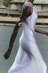 Vestido midi de satén color lila, con escote asimétrico y tirantes finos. Cierre lateral con cremallera oculta.