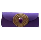 Sobre de fiesta violeta de tela tejida con aplique central de cristales dorados y ágata violeta. Incluye asa de cadena dorada para llevar al hombro.