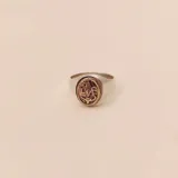 Anillo plateado con aplique ovalado dorado con el símbolo de enfermería.
