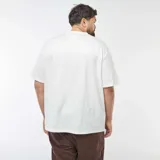 Camiseta blanca de punto con bordados all over, cuello redondo y mangas cortas.
