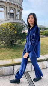 Camisa azul de terciopelo, corte oversize, con cuello camisero, manga larga y cierre frontal con botones.