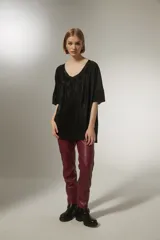 Blusa negra con cuello en V y mangas cortas, de tejido plisado.