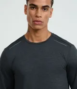 Remera deportiva de manga larga para hombre, color gris azulado jaspeado, con cuello redondo y costuras visibles en hombros y cuello.