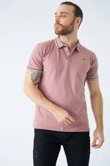 Remera cuello polo blanca de piqué, corte regular, manga corta, logo estampado y terminaciones a contratono en cuello y mangas con rayas rojas, grises y azules.