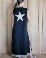 Vestido largo negro sin mangas, con cuello redondo y una estrella blanca estampada en la espalda. Presenta aberturas laterales en el ruedo.