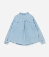 Camisa de jean de algodón, color celeste claro lavado, con cuello tradicional, manga larga y bolsillo de parche en el pecho. Presenta un cierre frontal con botones metálicos.
