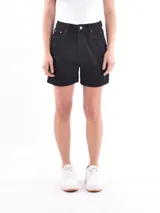 Short de jean negro, tiro alto, con corte recto y largo a mitad del muslo. Presenta roturas sutiles y dobladillo deshilachado en el ruedo.