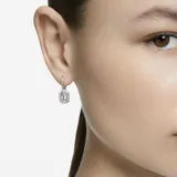 Aros colgantes Swarovski de la colección Millenia, con forma de argolla y cristal octogonal blanco con engarce pavé. Cierre a presión. Baño de rodio.