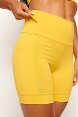 Conjunto deportivo negro compuesto por un top con diseño nadador, bolsillo trasero y detalles reflectivos, y un biker con cinturón 360° con bolsillo interno, bolsillos laterales y detalles reflectivos.