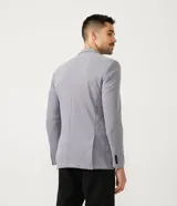 Blazer masculino color gris claro, de tejido liso con textura casual, con solapas, bolsillos amplios de parche en la parte delantera y un bolsillo superior. Cierre frontal de un solo botón.
