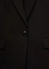 Blazer azul marino con cuello de pico y solapa, hombros estructurados, diseño entallado y dos bolsillos de ribete en la parte delantera.